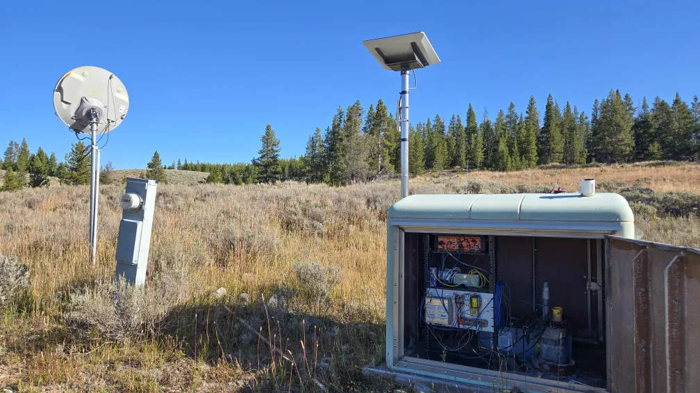 Green enclosure box with the door open to reveal station components.