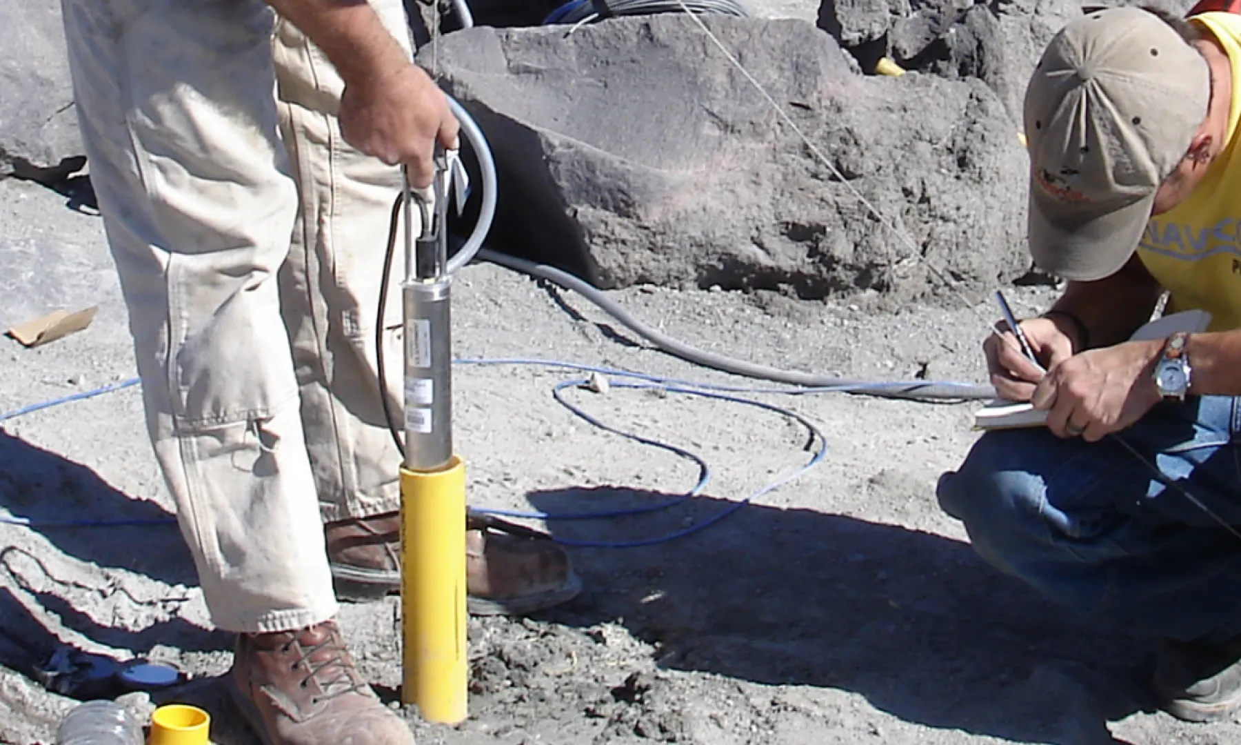 Two engineers installing a borehole tiltmeter.