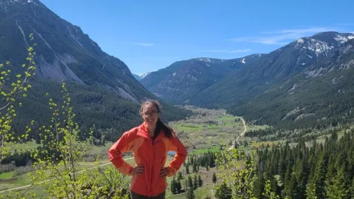 URISE intern Anah smiling with mountains in the background.