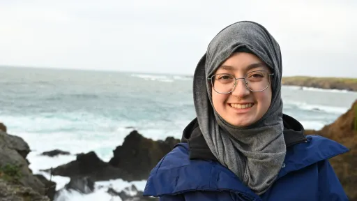 URISE intern Masooma Hasnain headshot in front of the ocean and rocks. 