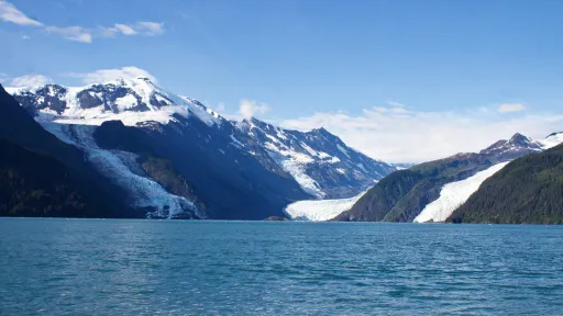 photo from a boat looking towards mountains and a glacier