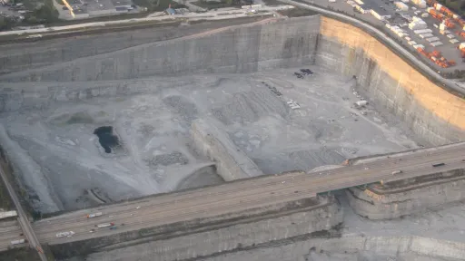 Overhead photo of an urban quarry with an interstate highway running across the middle.