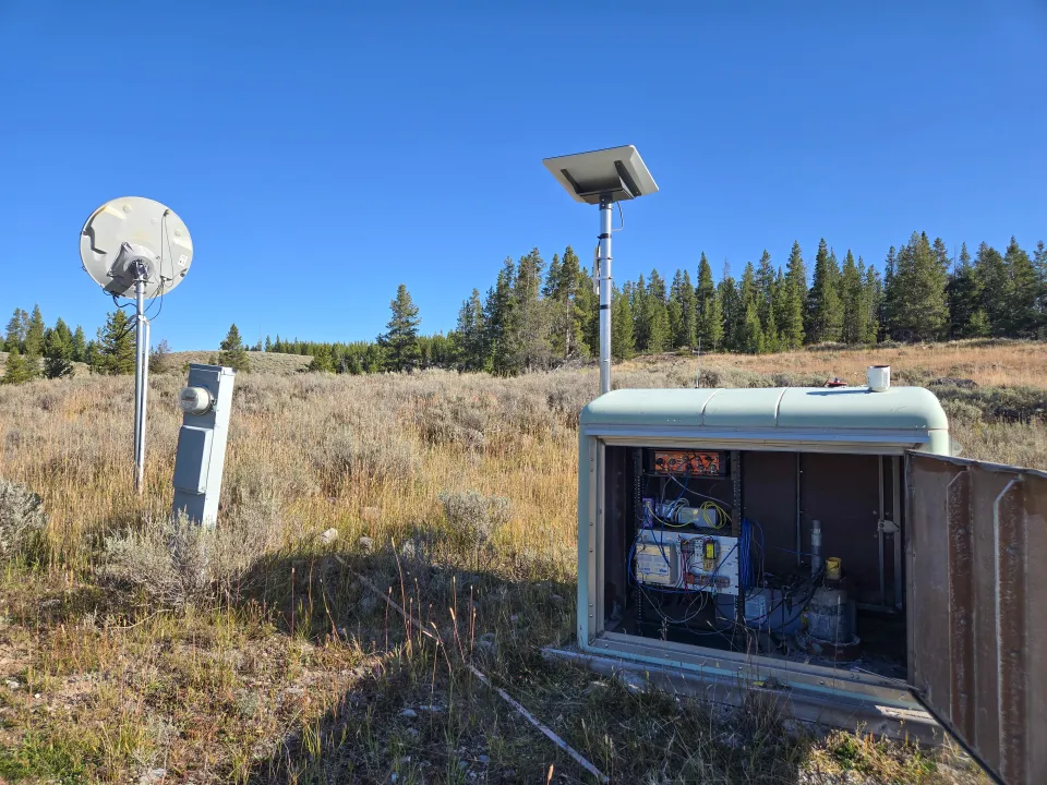 Green enclosure box with the door open to reveal station components.