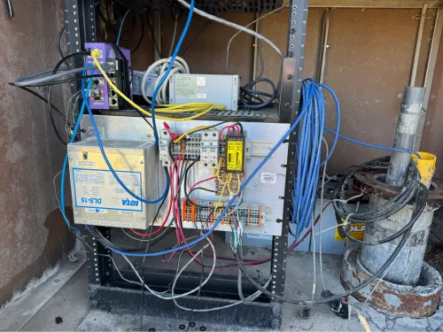 Cables and various components connected inside the enclosure, next to the top of the borehole.