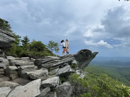 Jaden standing with another person on a large rock outcrop.