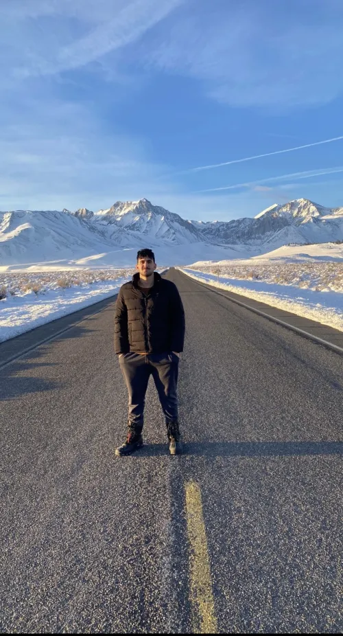 Hassan standing on a road in front of the mountains.
