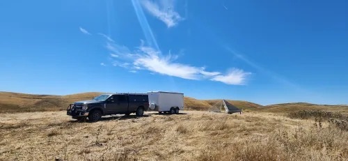 work truck with trailer parked near corner reflector