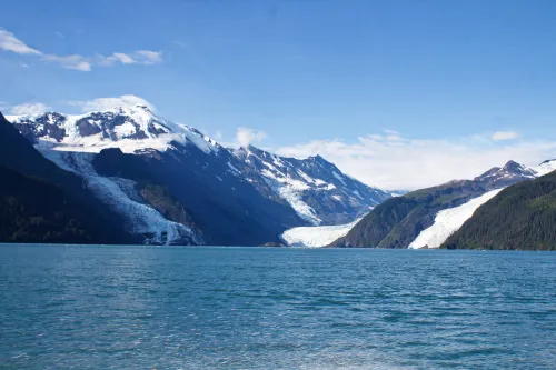 photo from a boat looking towards mountains and a glacier