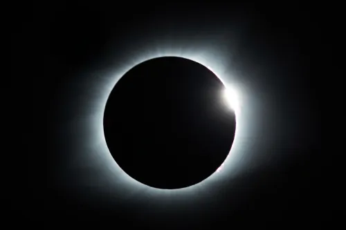 photo of near total solar eclipse, just a small bright spot peeking out on one edge